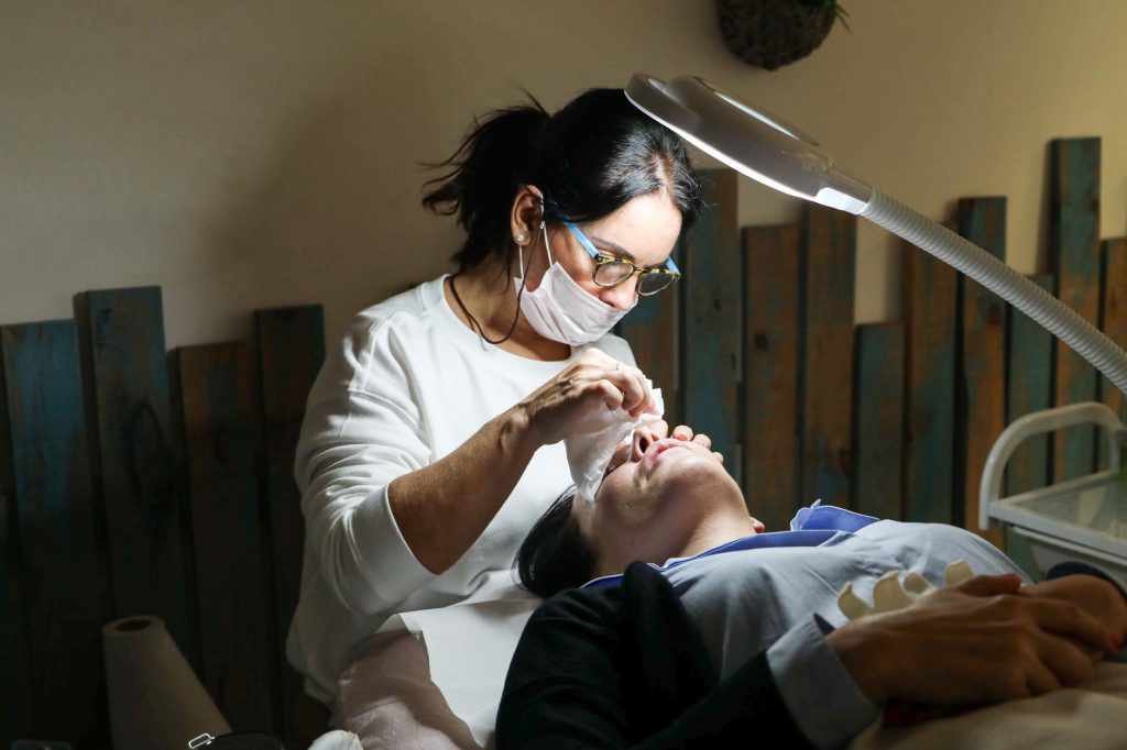 Praticienne effectuant un soin du cuir chevelu sur cliente à table Head Spa professionnelle dans un institut spa haut de gamme.