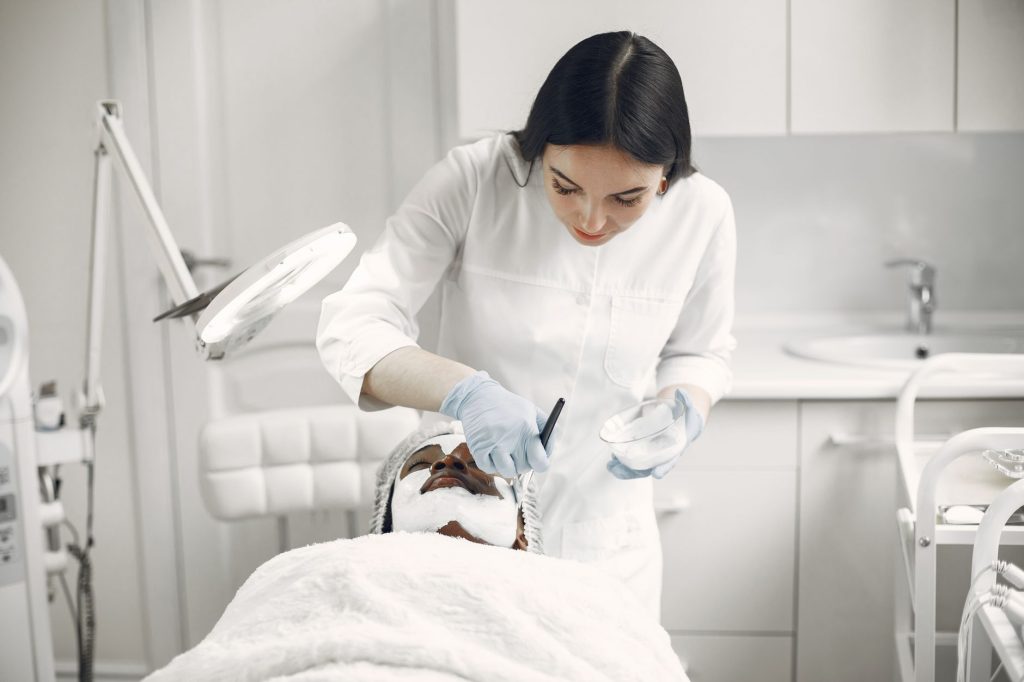 Praticienne ajustant une table Head Spa professionnelle haut de gamme dans un institut de beauté zen