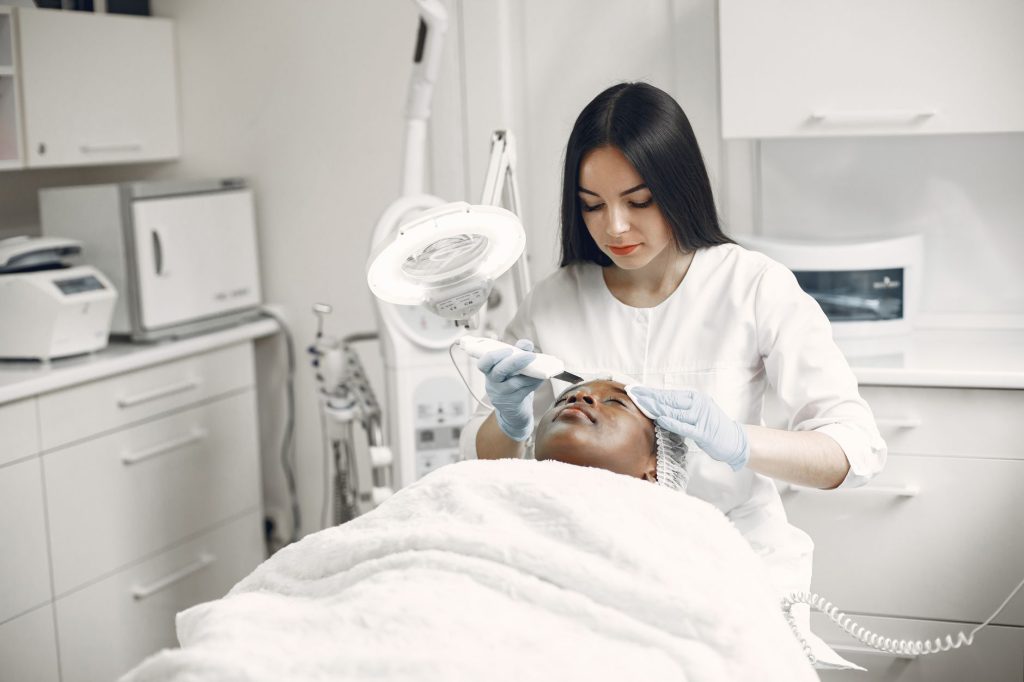 Praticienne utilisant un trichoscope professionnel pour examiner le cuir chevelu d'une cliente dans un institut de spa capillaire haut de gamme