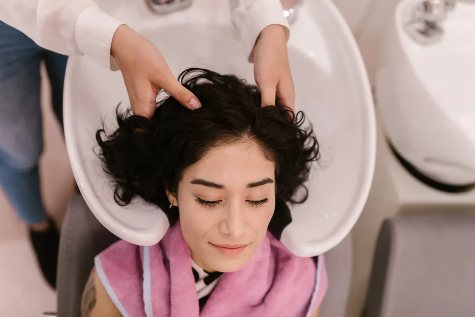 Praticienne effectuant un soin du cuir chevelu professionnel à une table Head Spa dans un institut haut de gamme