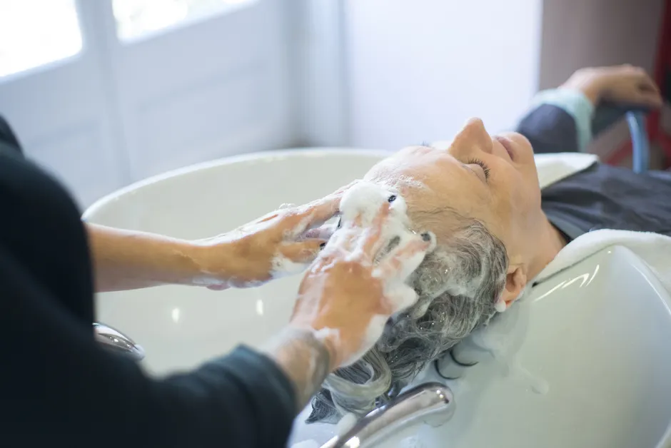 Praticienne effectuant un soin du cuir chevelu professionnel à l'aide d'un équipement Head Spa haut de gamme en cabine spa.