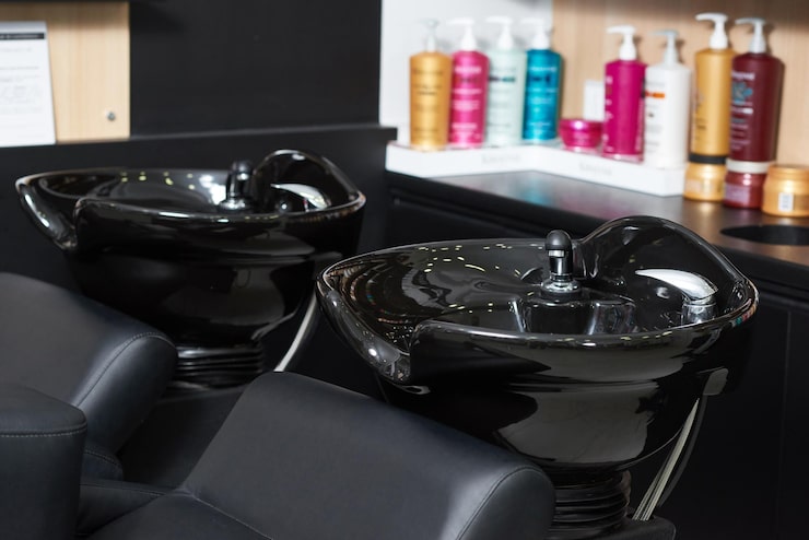Deux bacs à shampoing noirs en céramique installés dans un salon de coiffure moderne