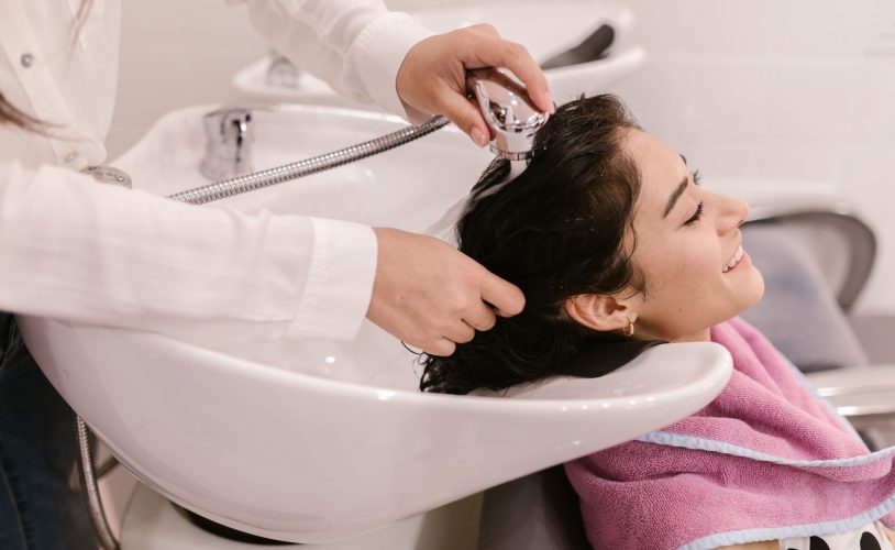 Cliente recevant un soin head spa professionnel dans un institut haut de gamme avec matériel spécialisé.