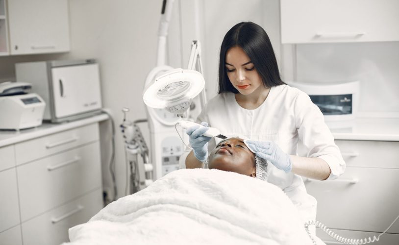 Praticienne utilisant un trichoscope professionnel pour examiner le cuir chevelu d'une cliente dans un institut de spa capillaire haut de gamme