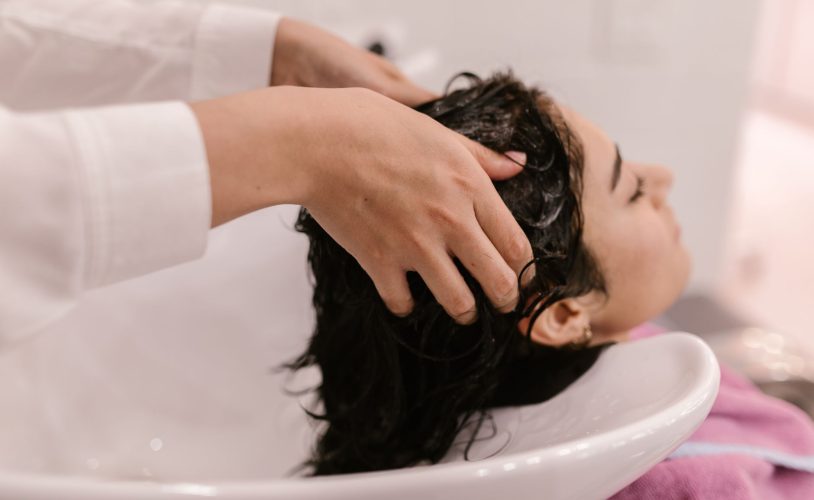 Praticienne effectuant un massage du cuir chevelu à une table Head Spa professionnelle dans un institut haut de gamme