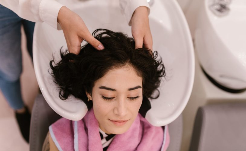Praticienne effectuant un soin du cuir chevelu sur une table de head spa professionnel en institut haut de gamme